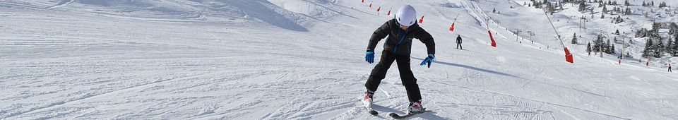 Niño aprendiendo a esquiar en pista de nieve